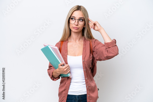 Pretty student blonde woman isolated on white background having doubts and thinking