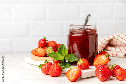 Homemade strawberry jam in glass jar and fresh strawberries  photo