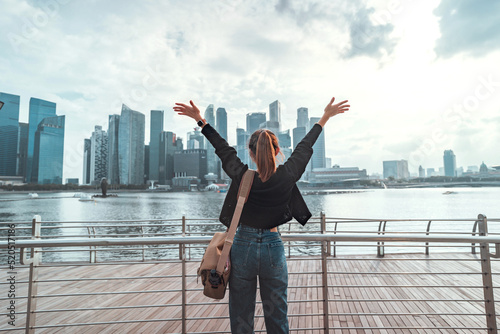 Photography Rear view of young tourist woman relaxing with her arms raised to her head enjoy