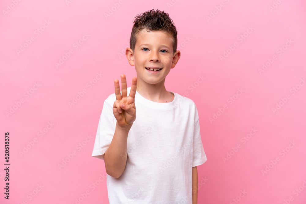 Little caucasian boy isolated on pink background happy and counting three with fingers Little caucasian boy isolated on pink background happy and counting three with fingers