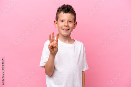 Little caucasian boy isolated on pink background happy and counting three with fingers