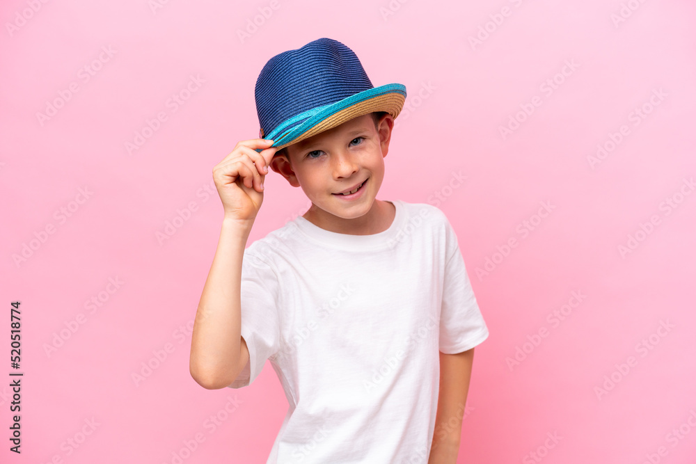 Little caucasian boy wearing a hat isolated on pink background