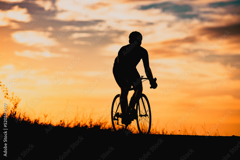 Obraz premium cyclist silhouette at sunset sports and fitness concept
