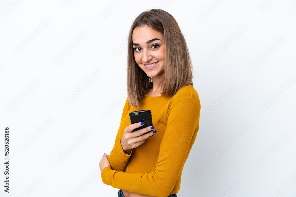 Fototapeta premium Young caucasian woman isolated on white background holding a mobile phone and with arms crossed