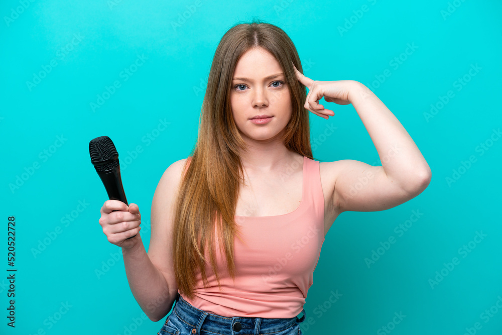 Singer caucasian woman picking up a microphone isolated on blue background having doubts and thinking Singer caucasian woman picking up a microphone isolated on blue background having doubts and thinking