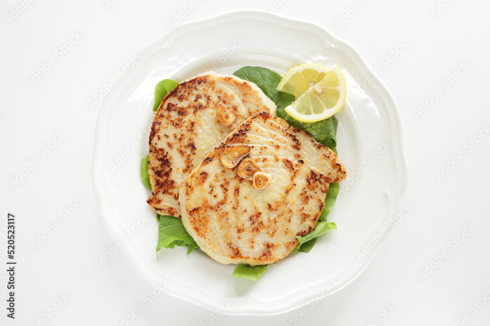 Asian food, butter pan fried swordfish fillet served lemon on lettuce