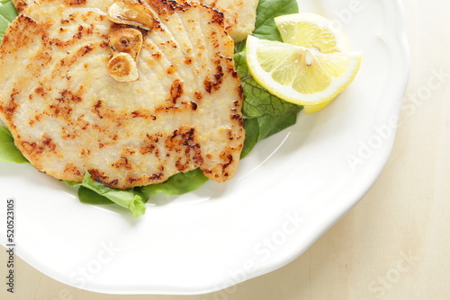 Asian food, butter pan fried swordfish fillet served lemon on lettuce