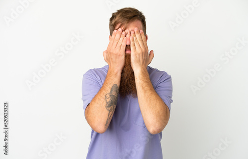 Young reddish caucasian man isolated on white background covering eyes by hands