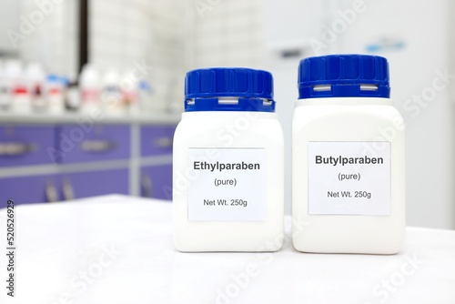 Selective focus of a bottle of ethylparaben and butylparaben parabens pure chemical compound used as preservative in cosmetics and pharmaceutical products. White laboratory background. photo