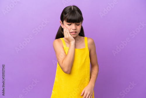 Little caucasian kid isolated on purple background with toothache