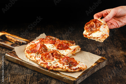Roman-style pizza with jamon serrano. Roman square pizza or Pinsa on thick dough, Italian cuisine