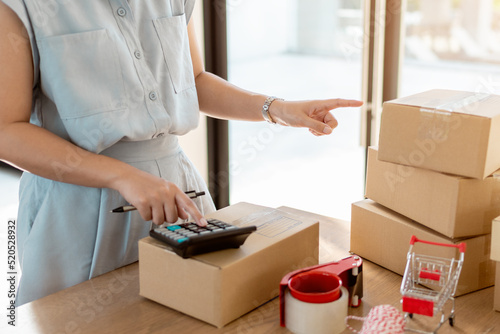 Close up online business owner prepares product for delivery to the customer. Online entrepreneur pointing finger for check retail order or counting parcel box for delivery to customer. © C_Production