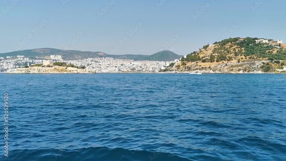 View from the sea to the city on the coast. The Aegean Sea, Turkey, Kusadasi. View from the sea to the city on the coast. The Aegean Sea, Turkey, Kusadasi.