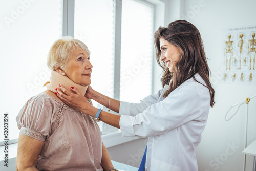 Wallpaper Mural Female doctor putting neck orthopaedic collar on adult injured woman. Doctor talking to a senior patient with cervical collar at the hospital.  Torontodigital.ca