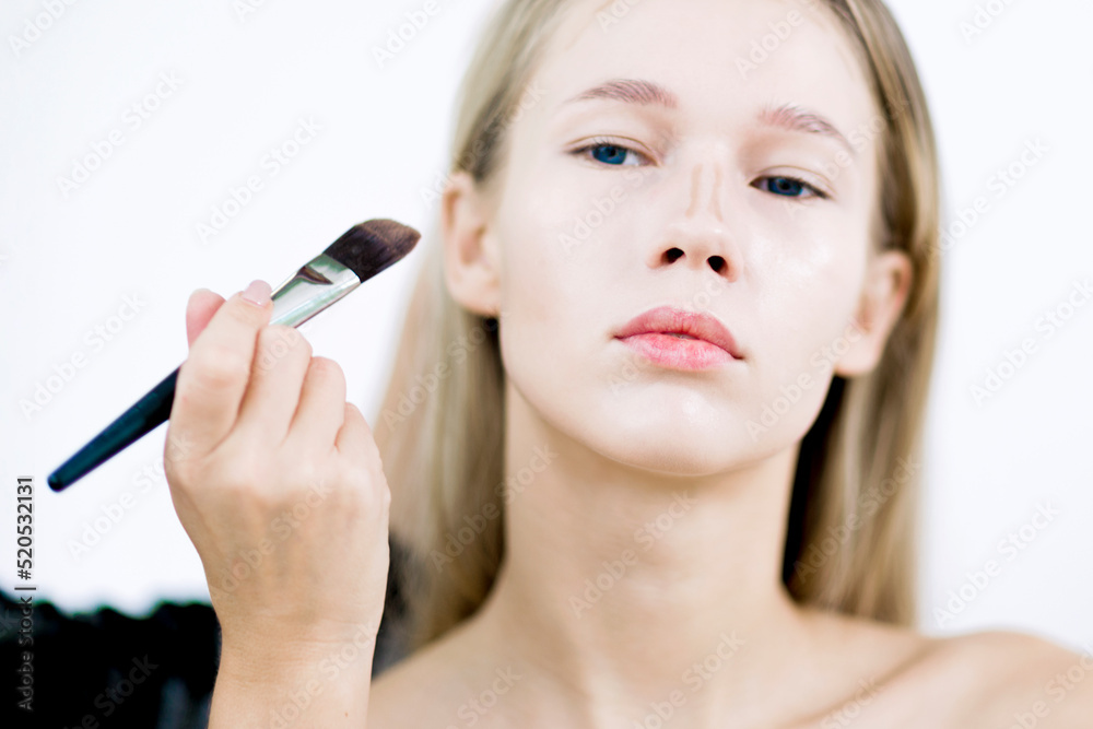 Fototapeta premium Makeup artist applies corrector. Makeup in the studio.