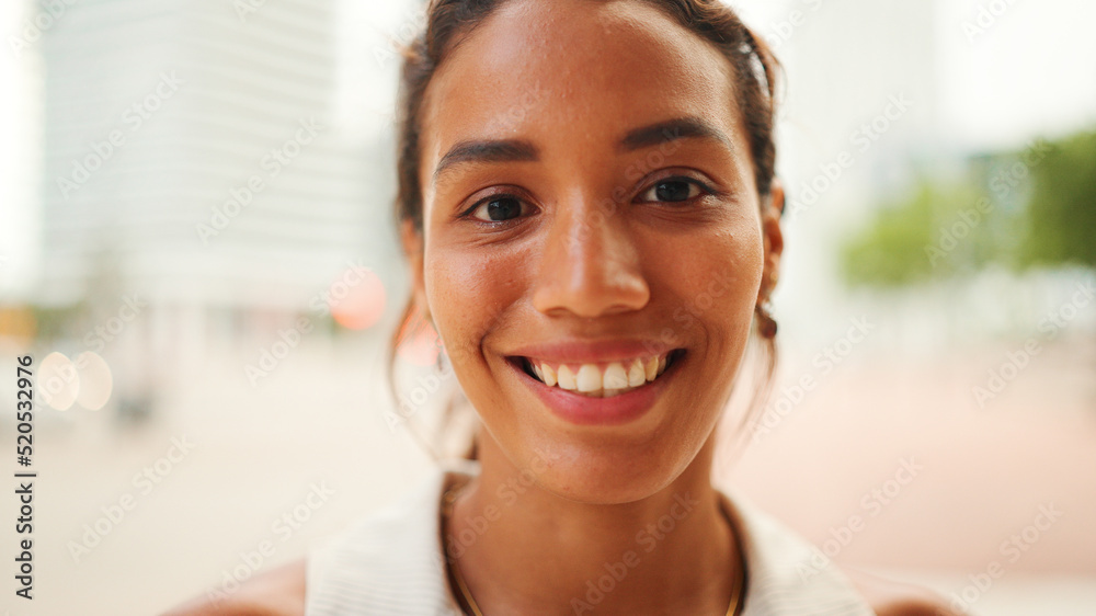 Close-up of the face of beautiful tanned woman with dark hair and expressive brown eyes looks at the camera with smile Close-up of the face of beautiful tanned woman with dark hair and expressive brown eyes looks at the camera with smile
