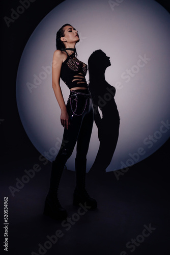 Hot sexual woman in latex suit on a dark background. Woman dominance concept