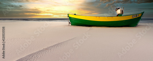 Sunset over Baltic Sea with fishing boat on the beach - Debki, Pomerania, Poland photo