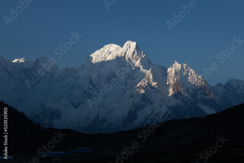 View of the mountain slopes and peaks with snow in the Himalayas in the Manaslu region at sunrise