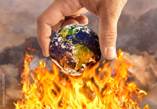 Human holding earth on fire, global warming concept