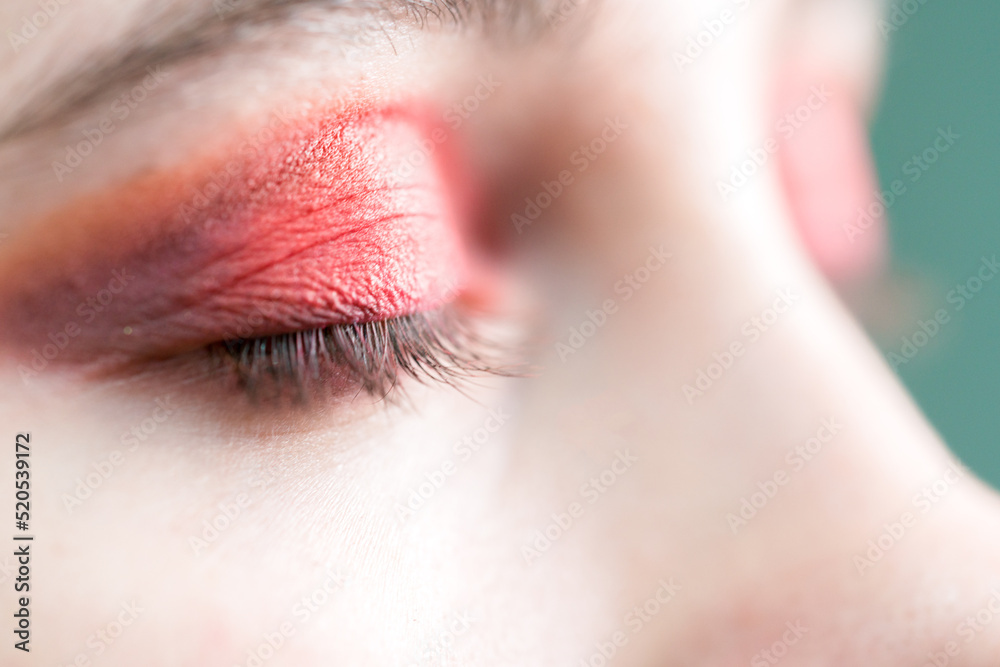 Fototapeta premium Red eyeshadow. Close up of a girl's closed eye.