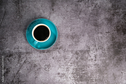 black coffee in a blue ceramic cup on the old gray cement floor