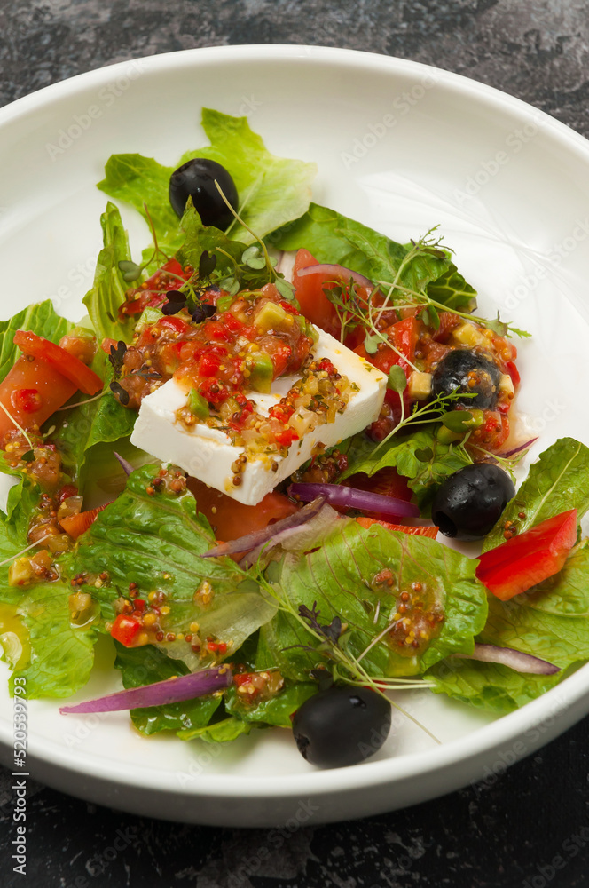 vegetable salad with pickled cheese on a white plate in a restaurant vegetable salad with pickled cheese on a white plate in a restaurant