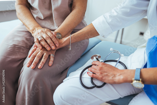 Friendly female doctor's hands holding female patient's hand for encouragement and empathy. Partnership trust and medical ethics concept. Doctor giving hope.