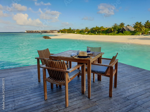 wooden table and chairs on the background of the sea © Oleg