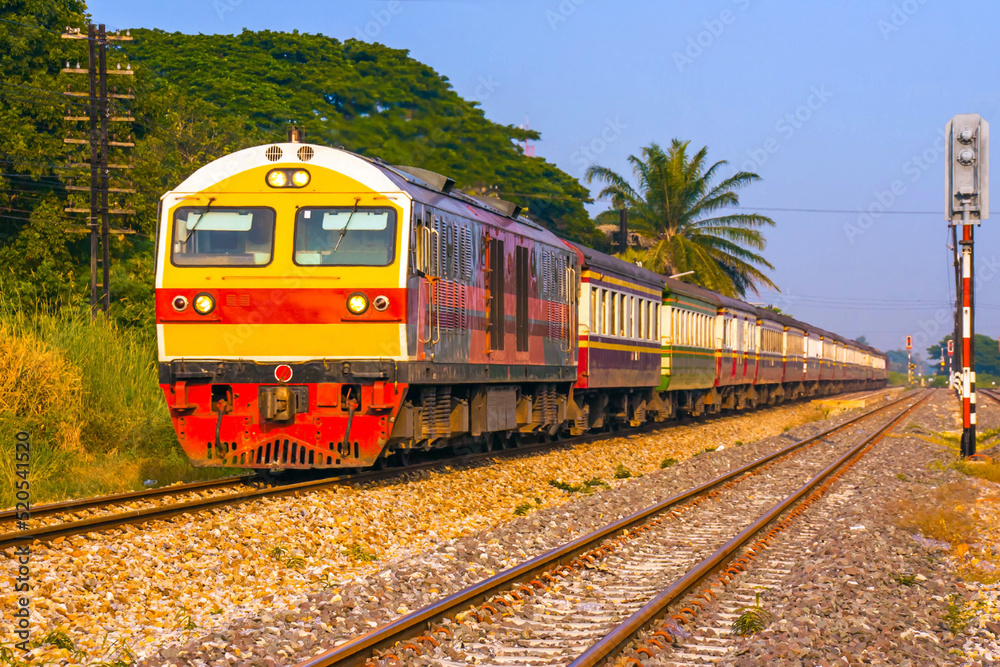 Passenger train by diesel locomotive on the railway in Thailand