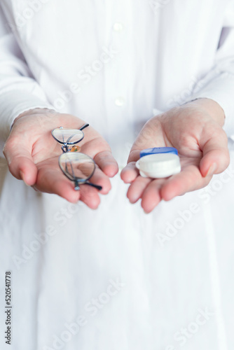 doctor with glasses for vision and a container for contact lenses. healthcare and medicine, healthcare and treatment concept.
