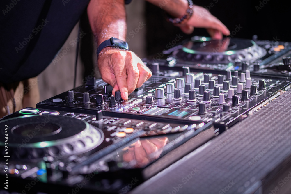 Obraz premium Dj playing disco house progressive electro music at the concert. DJ hands on equipment