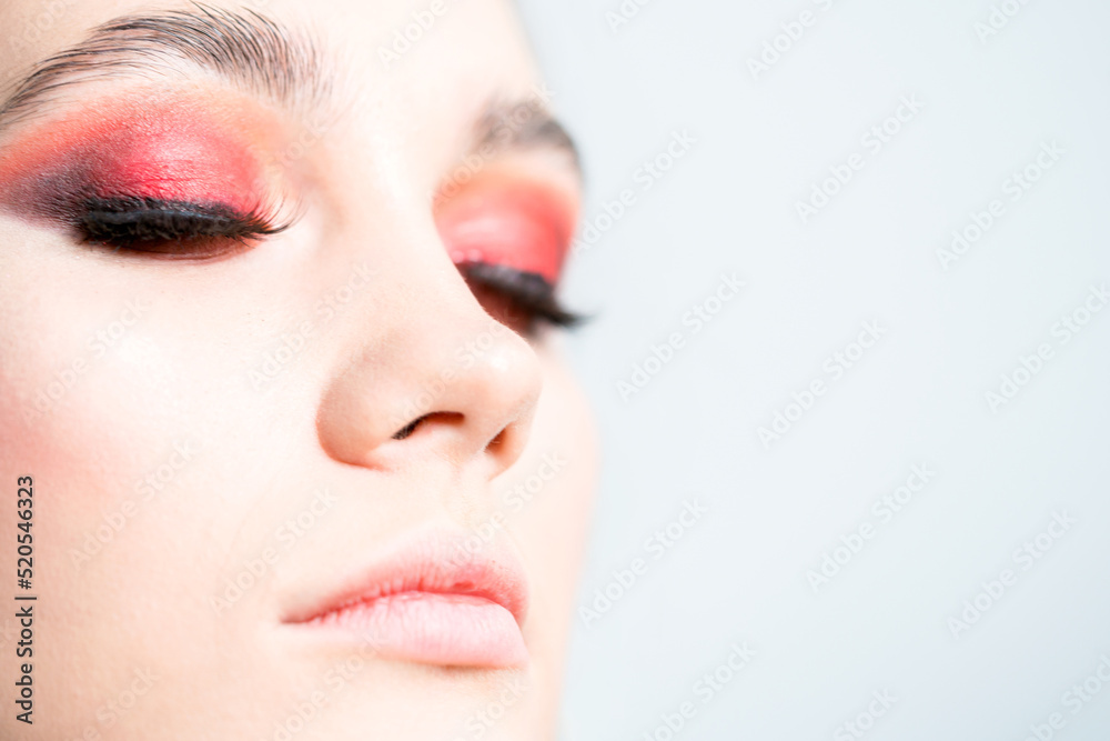 Fototapeta premium Bright red eye makeup close-up. On a white background.