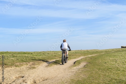 Back view of a middle-aged male riding a bicycle photo