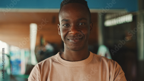 Close-up of smiling happy young african guy looking at camera