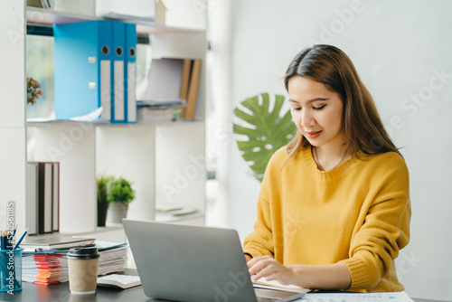 Asian business woman have the joy of talking on the phone, laptop and tablet on the office desk