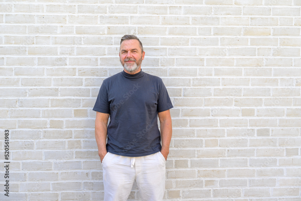Trendy casual man posing in front of a brick wall Trendy casual man posing in front of a brick wall