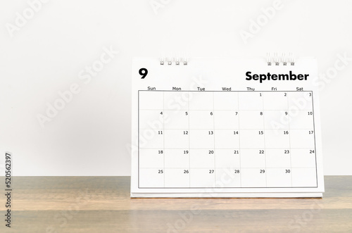 The September 2022 desk calendar on wooden background.