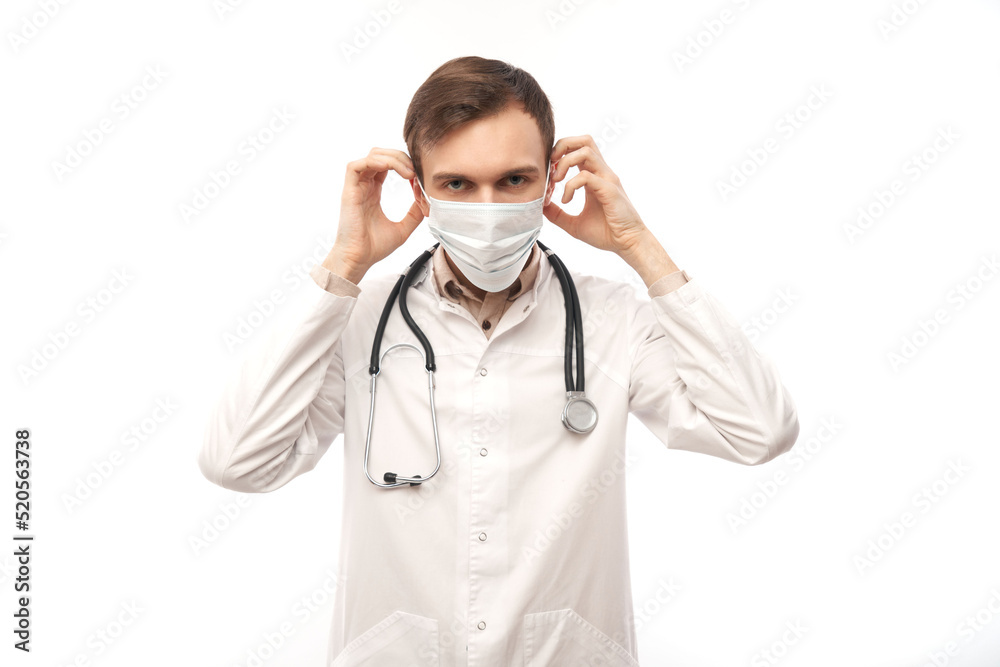 Portrait of doctor in white medical coat and protective face mask isolated on white background with copy space Portrait of doctor in white medical coat and protective face mask isolated on white background with copy space