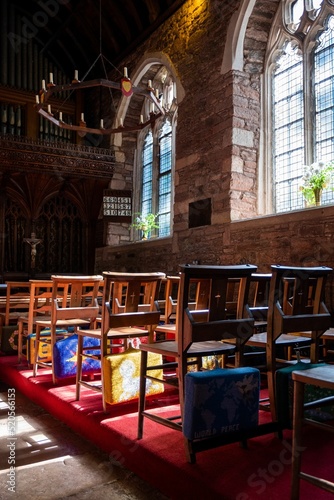 Vertical of prayer cushions on the back of wooden chairs in Cockington Court Church, Devon, England photo