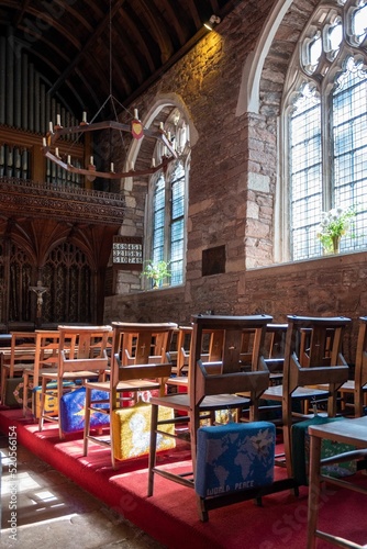 Vertical of prayer cushions on the back of wooden chairs in Cockington Court Church, Devon, England photo