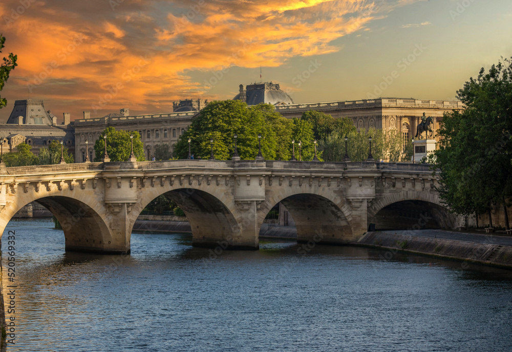 The Pont Neuf over the Seine river in the French city of Paris and under a beautiful sunset. Paris is divided by the Seine river and this beautiful European city is full of beautiful bridges.