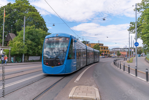 Tram passing the ABBA museum and Tivoli platform on the way to the central station T Centralen, a sunny summer day in Stockholm