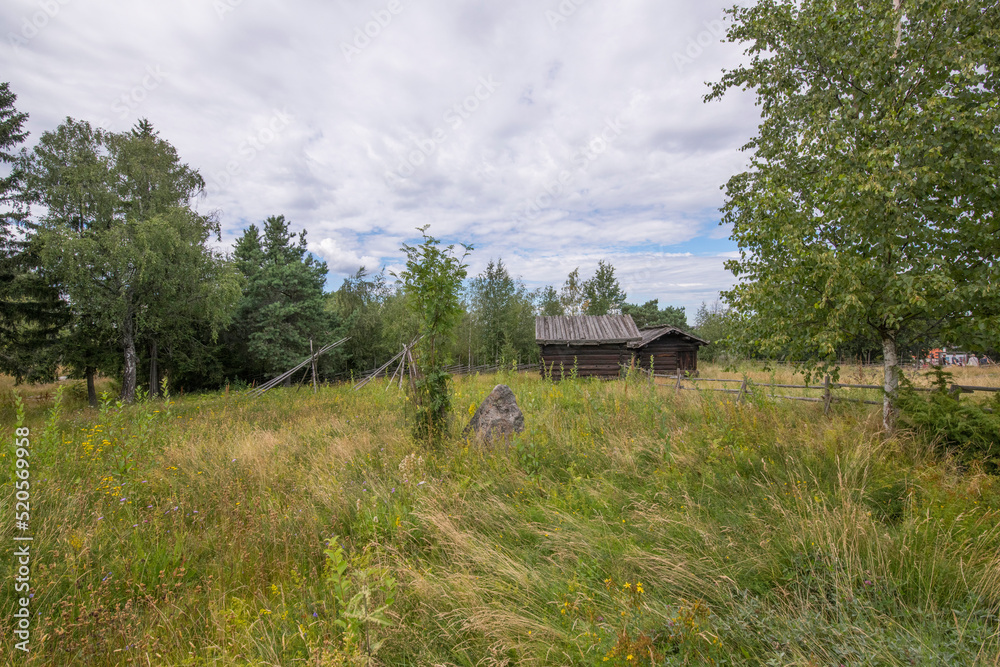 Old log shed in a meadow a sunny summer day in Stockholm Old log shed in a meadow a sunny summer day in Stockholm