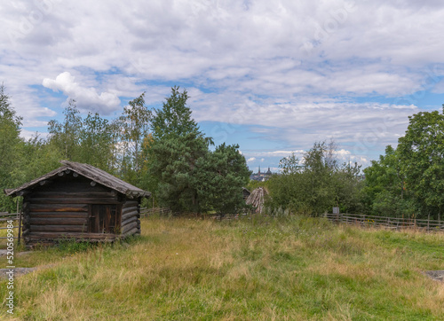 Old log shed in a meadow a sunny summer day in Stockholm