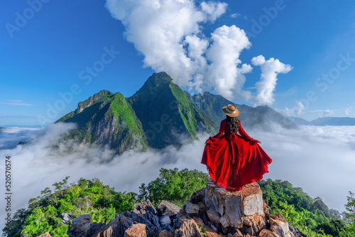 Asian girl on top of Viewpoint of Nong Khiaw - a secret village in Laos. Stunning scenery of limestone cliff valley covered with fog. photo