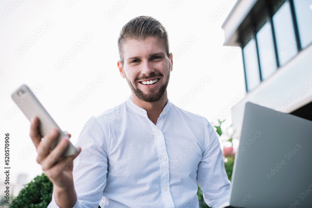 Cheerful man with smartphone and laptop Cheerful man with smartphone and laptop