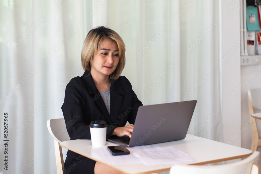Young attractive beautiful woman working intently , laptop and paperwork on the table while happy free time in coffee shop Young attractive beautiful woman working intently , laptop and paperwork on the table while happy free time in coffee shop