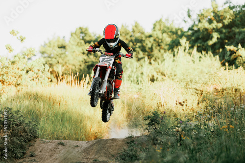 Live shot of junior sportsman, motorcyclist training on motorbike at hot summer day, outdoors. Motocross rider in action. Motocross sport, challenges