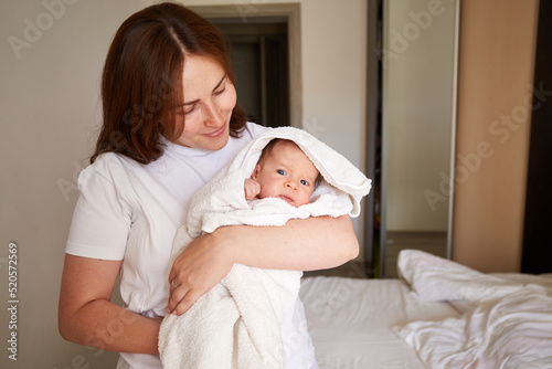 Mother holding her newborn baby. Home portrait of newborn baby and mother. Enjoying time together